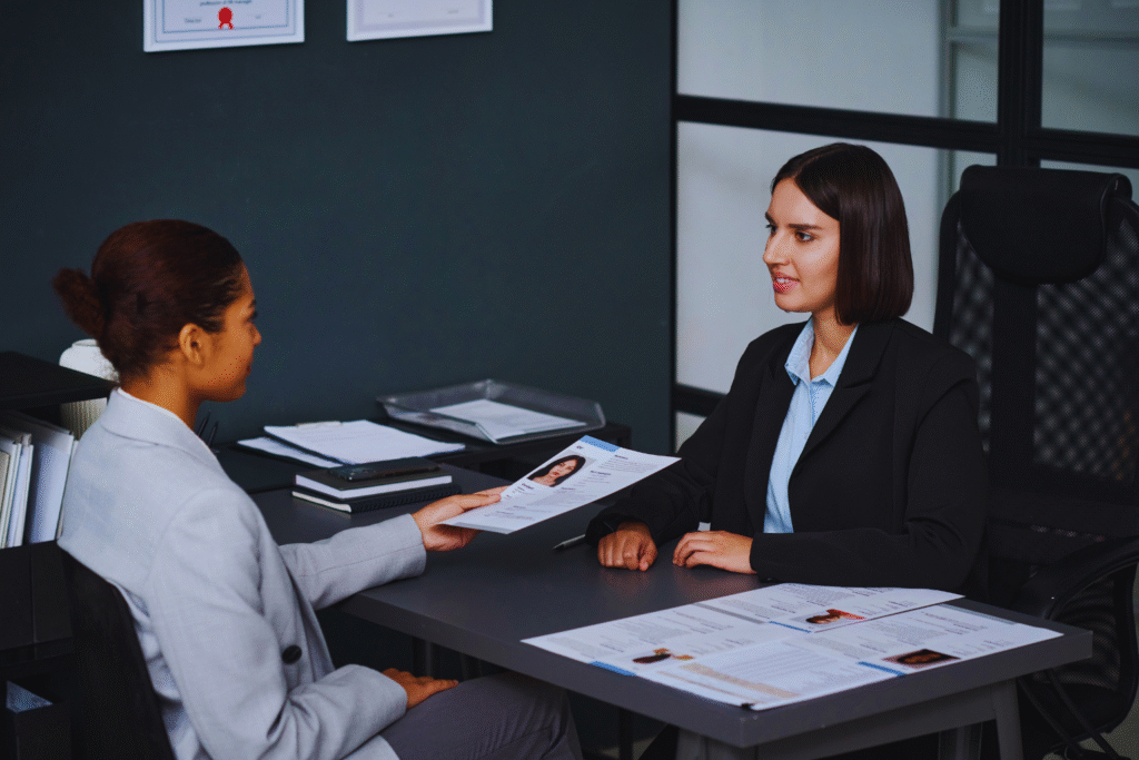 Two business professionals discussing RERA certification documents during a real estate compliance meeting in an office.
